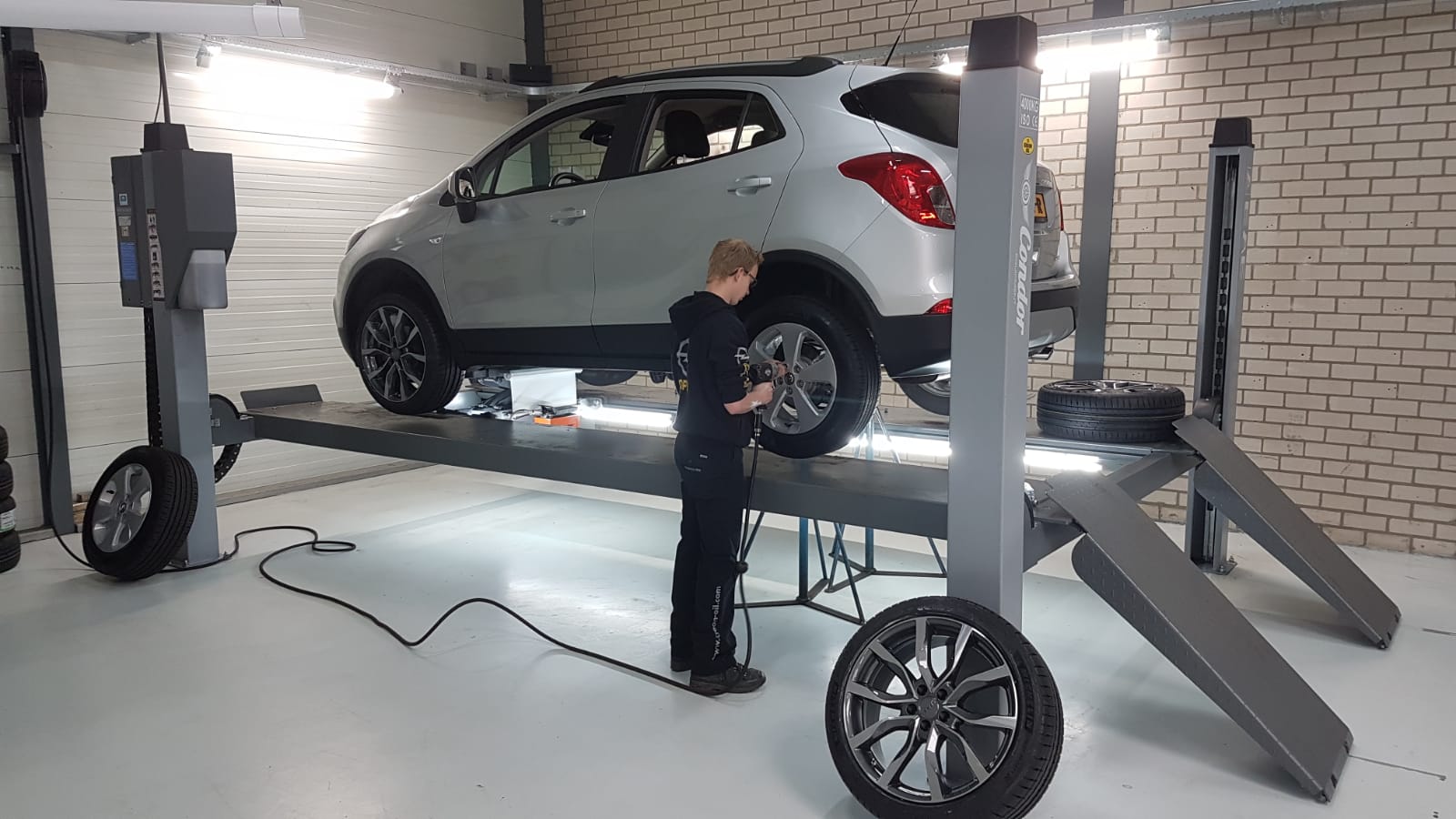 Monteur werkt aan een Opel Mokka op de uitlijnbrug